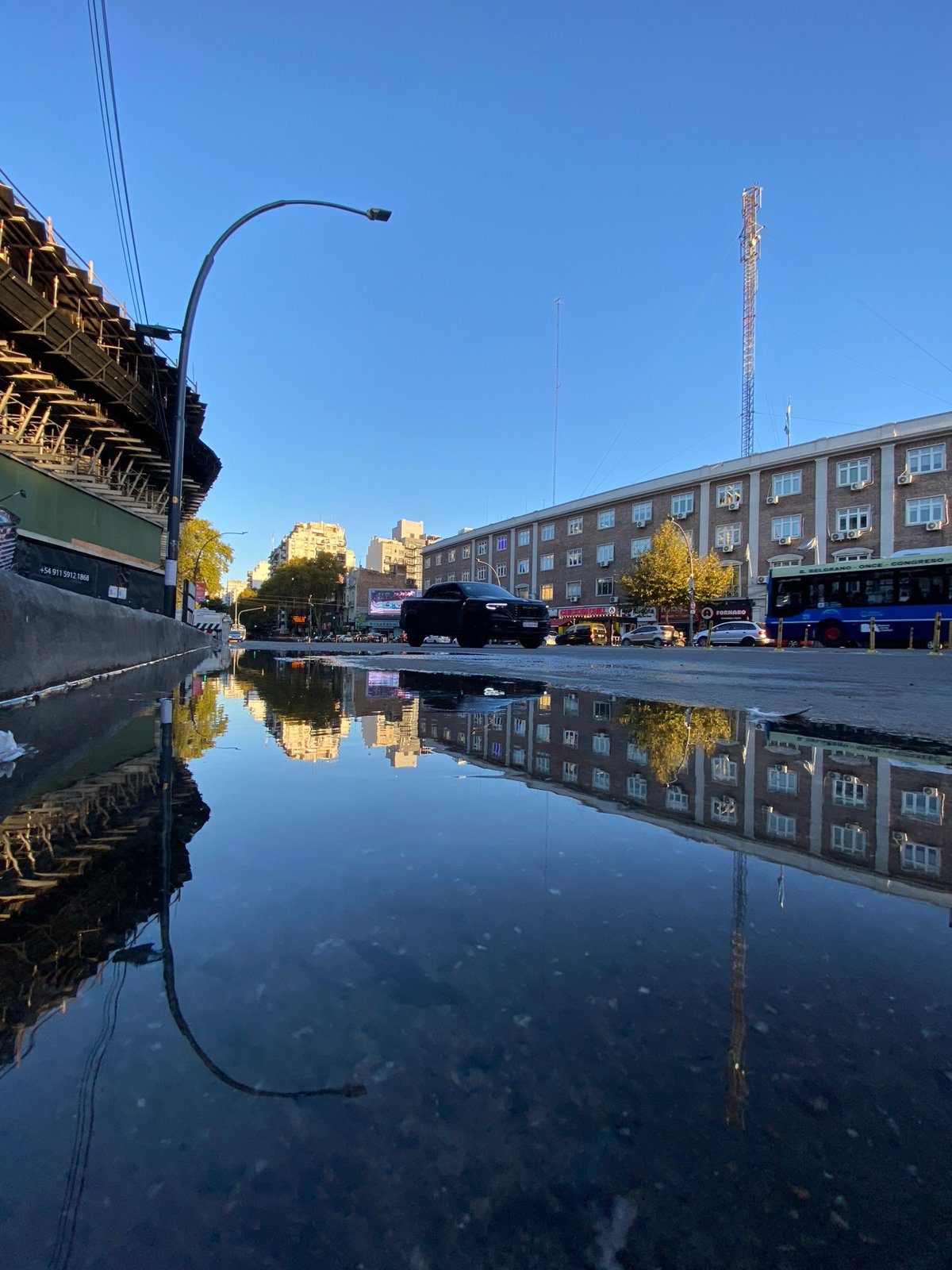 Building reflection captured in Buenos Aires street water