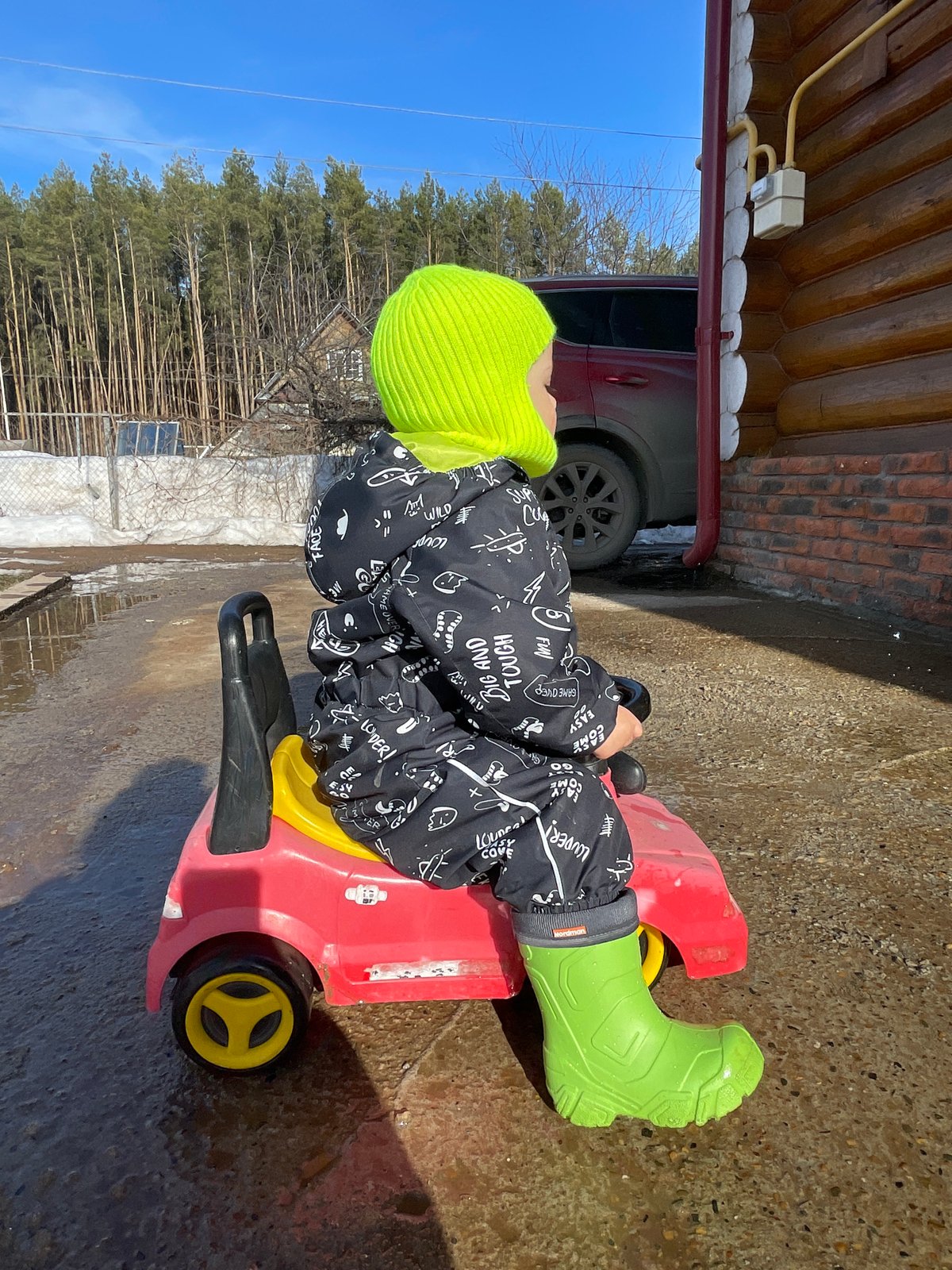 Child plays outdoors in melting snow in Zav'yalovo, Russia
