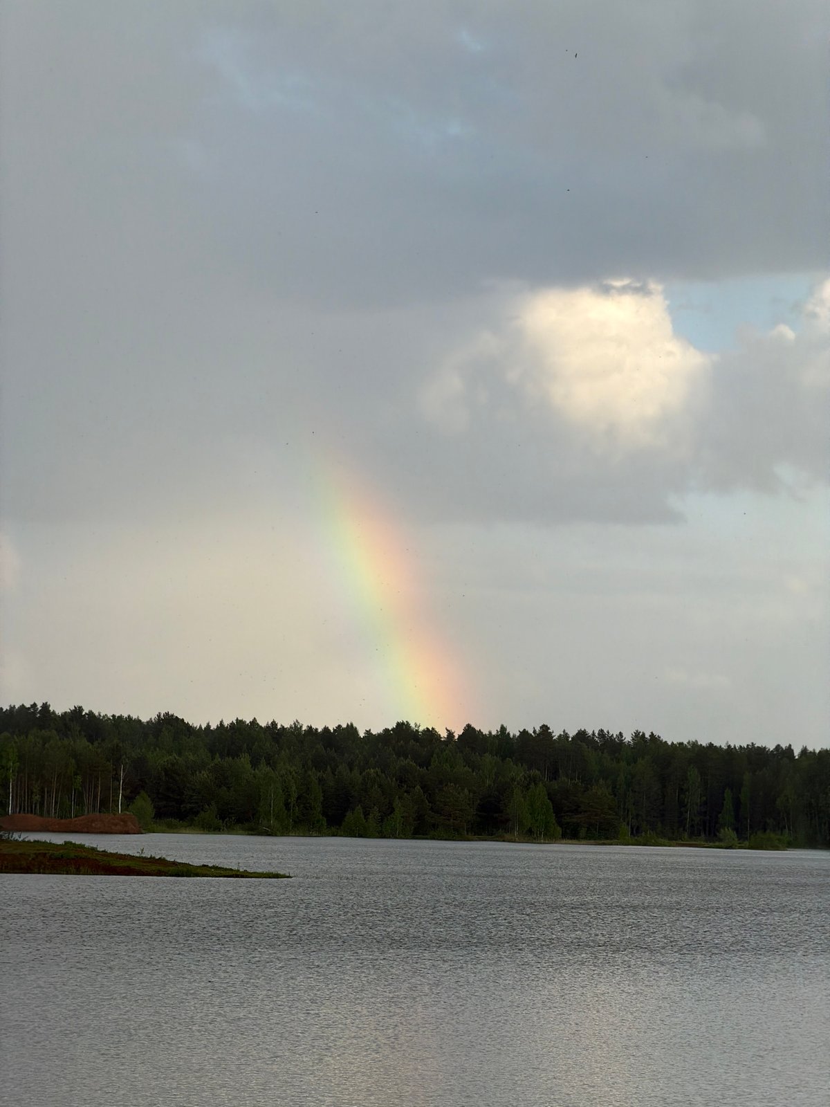 Rainbow appears over Russian forest landscape in Kanifol'nyi