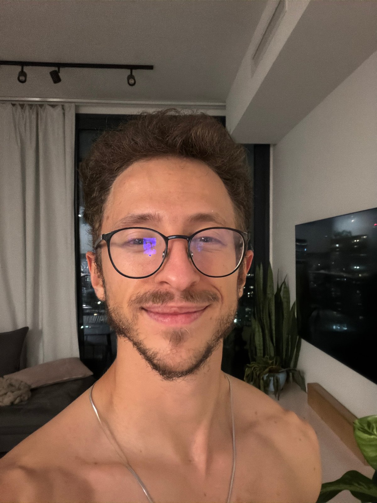 Portrait of smiling bearded man with glasses captured indoors