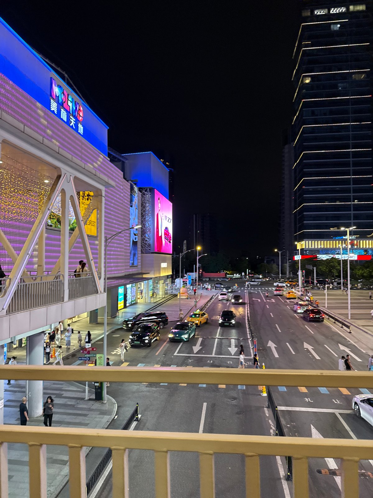 Nighttime entertainment district bustling with shoppers and carnival attractions