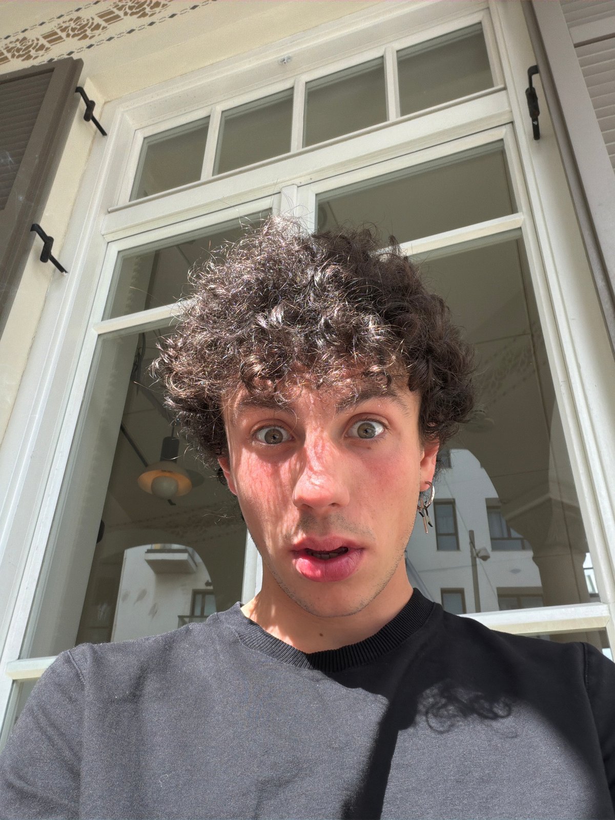 Man with surprised expression photographed through window in Tel Aviv