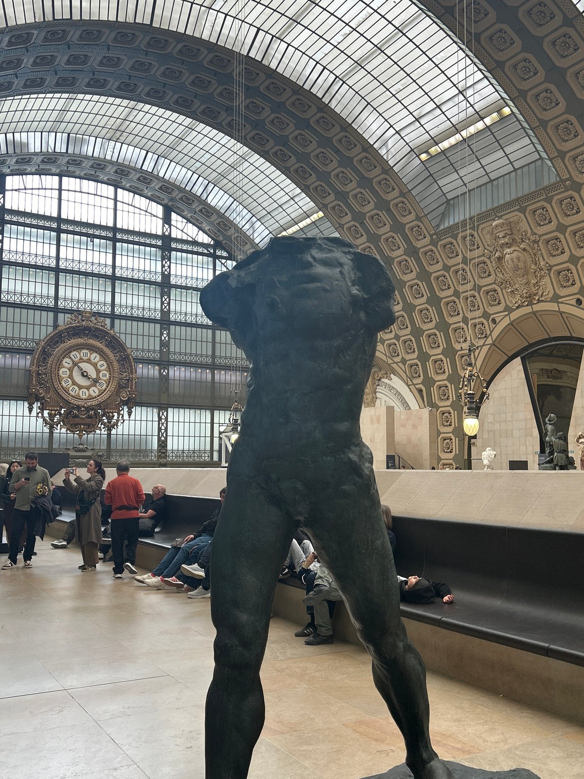 Visitor documents sculptures, ceiling art at Paris Musée d'Orsay