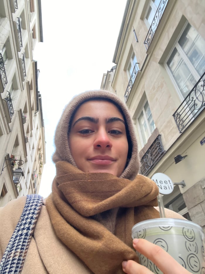 Woman takes selfies on narrow Paris street Sunday morning