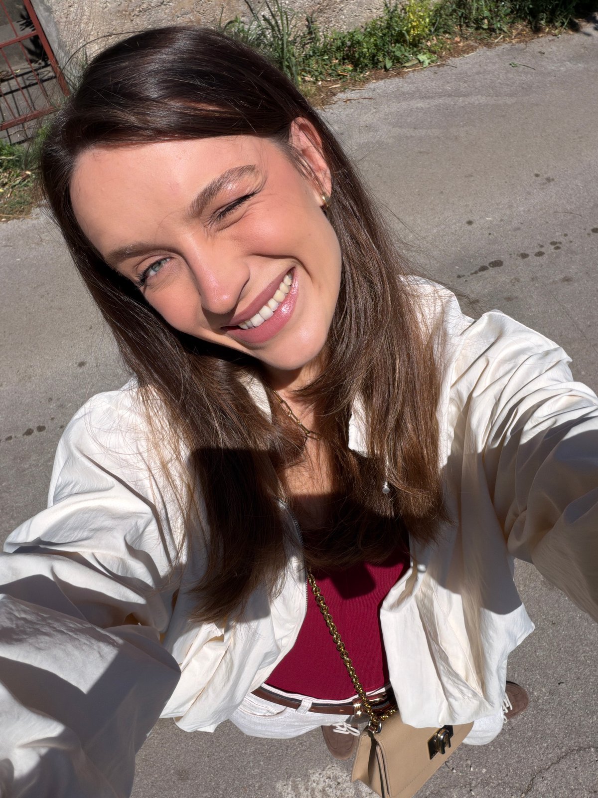 Woman films selfies on sunny streets in Budva, Montenegro