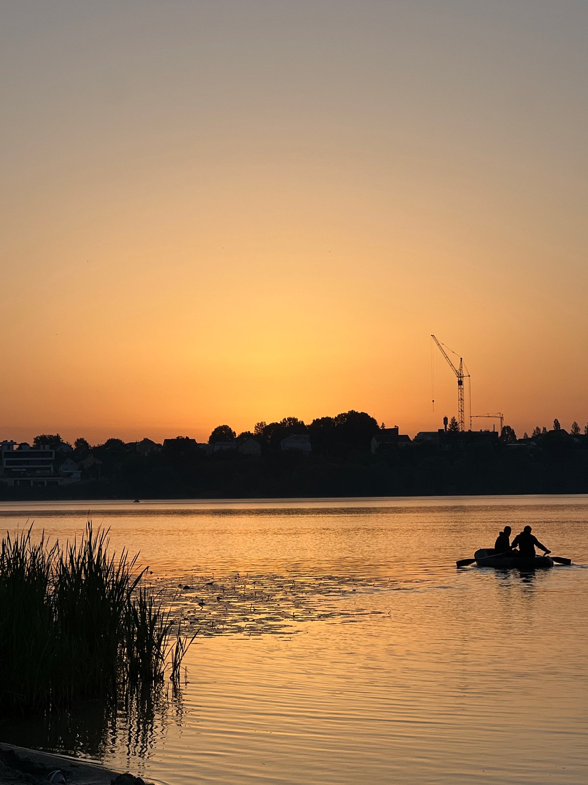 Golden sunset at Ternopil Pond, figure wading in the shallows