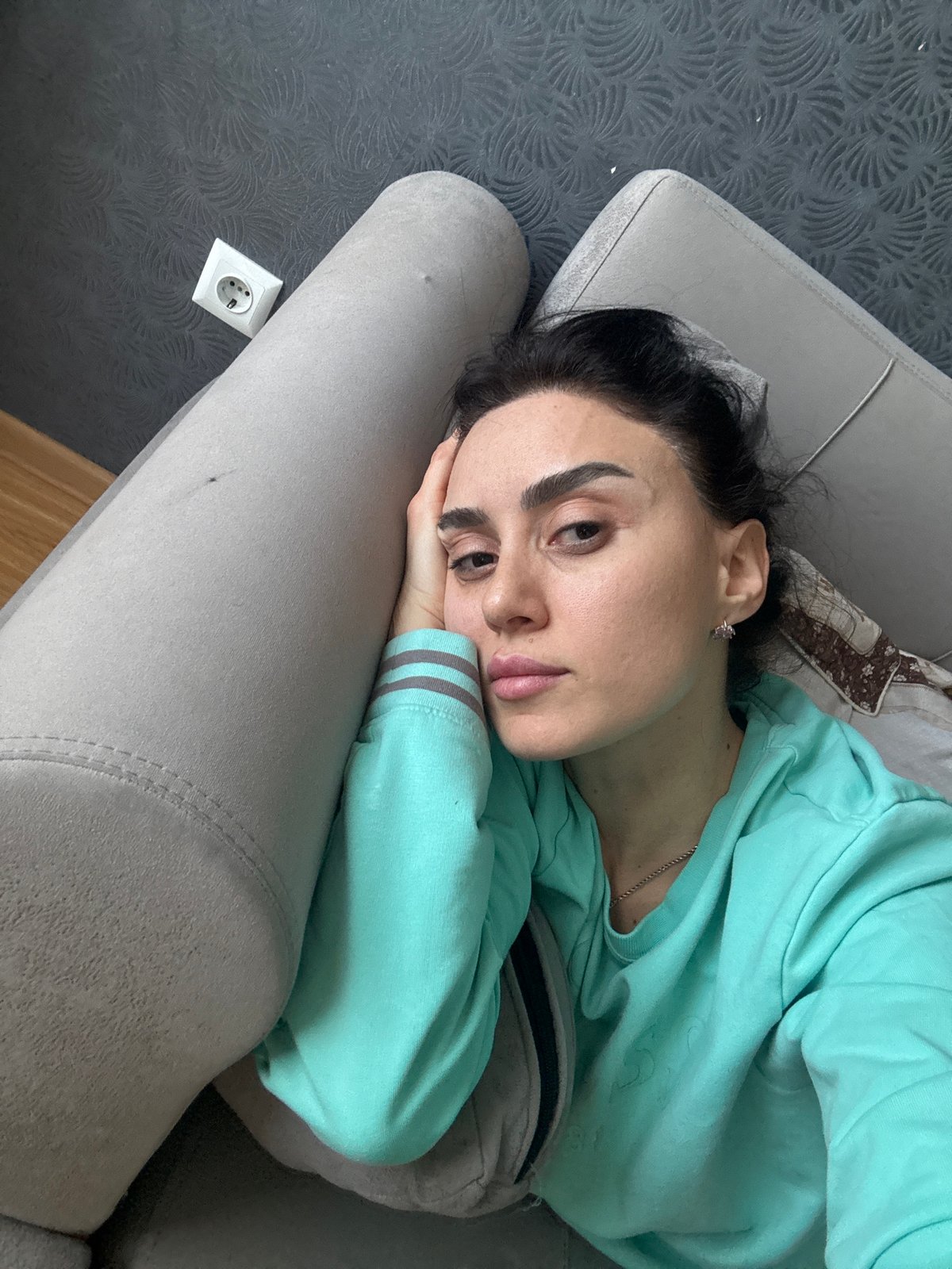 Woman rests on couch in Tbilisi home