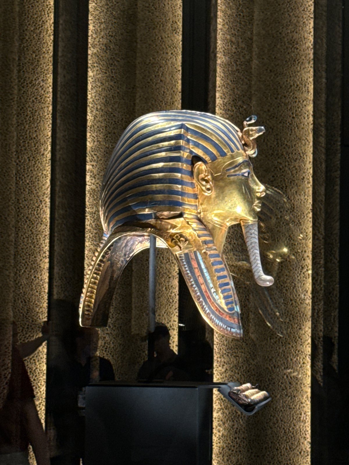 Visitors tour Grand Egyptian Museum viewing Tutankhamun mask, pharaoh statues