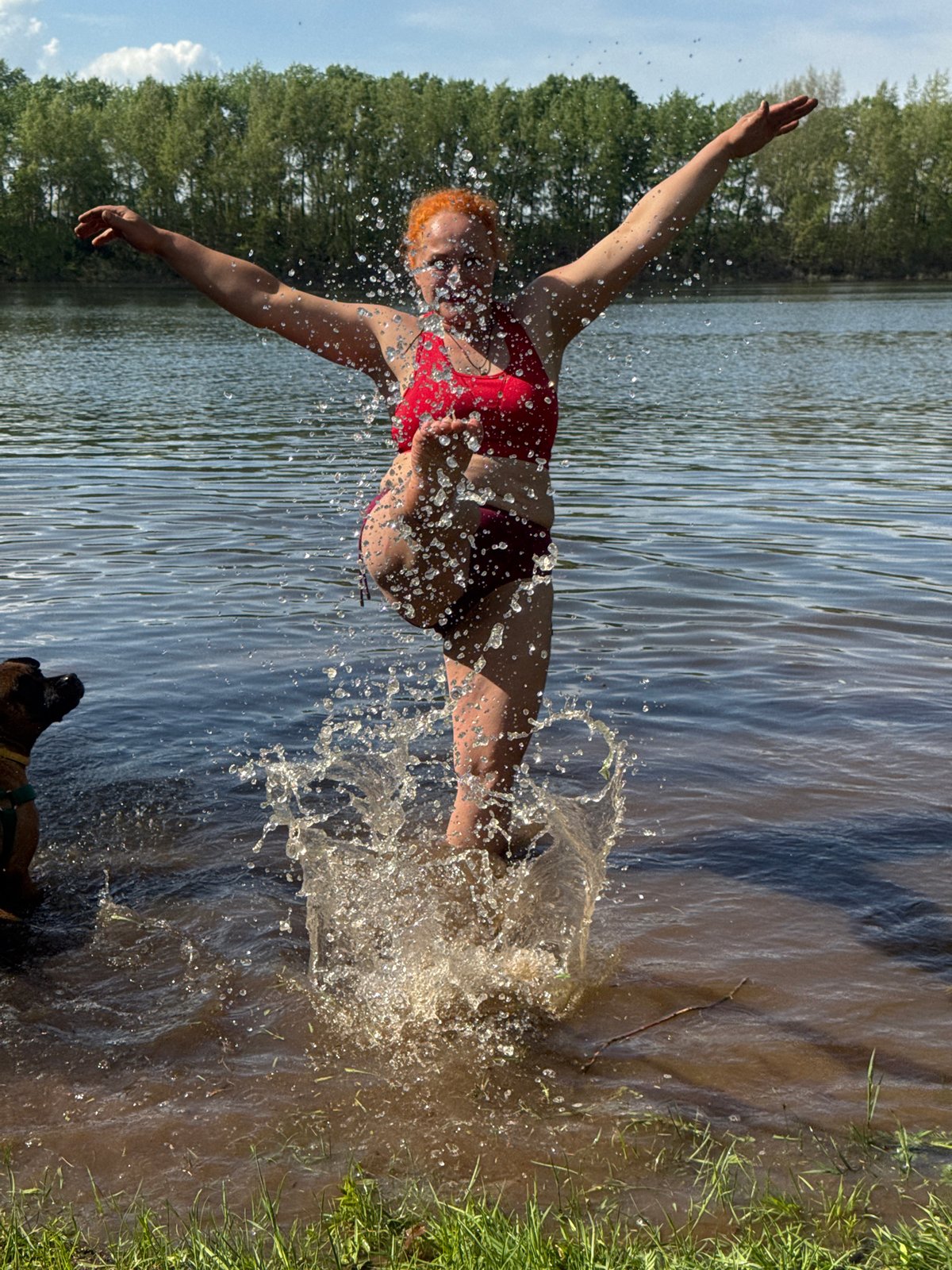 Woman and dog enjoy water play in Chaikovsky, Russia