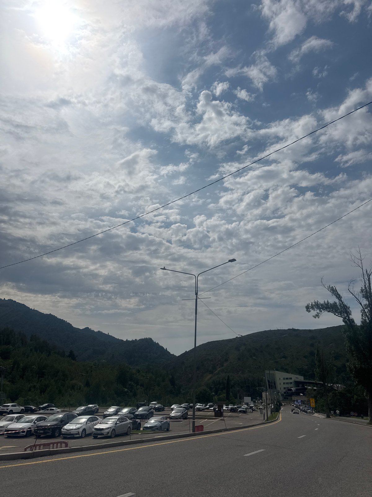 Almaty streets and mountains under a cloudy summer sky