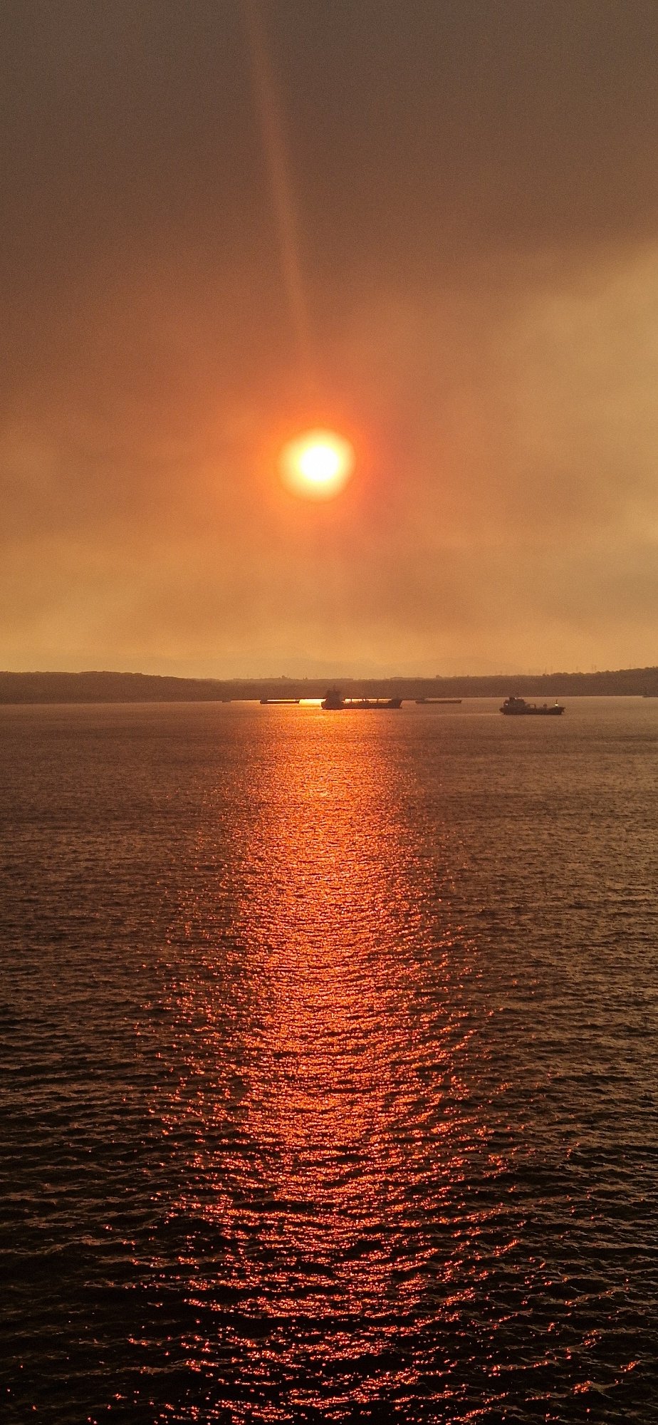 Superyacht cruises Gulf of Corinth at hazy sunset