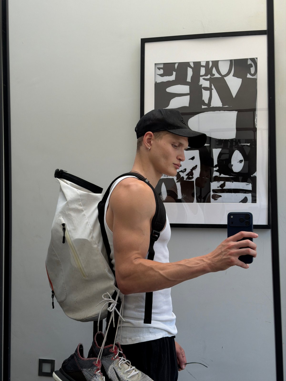Mirror selfie and artwork pose inside a London space.