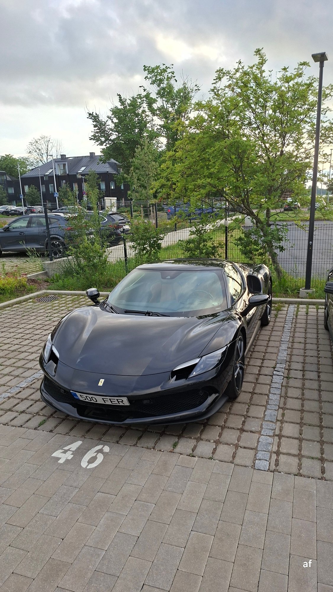Black Ferrari parked on a numbered lot in Tallinn