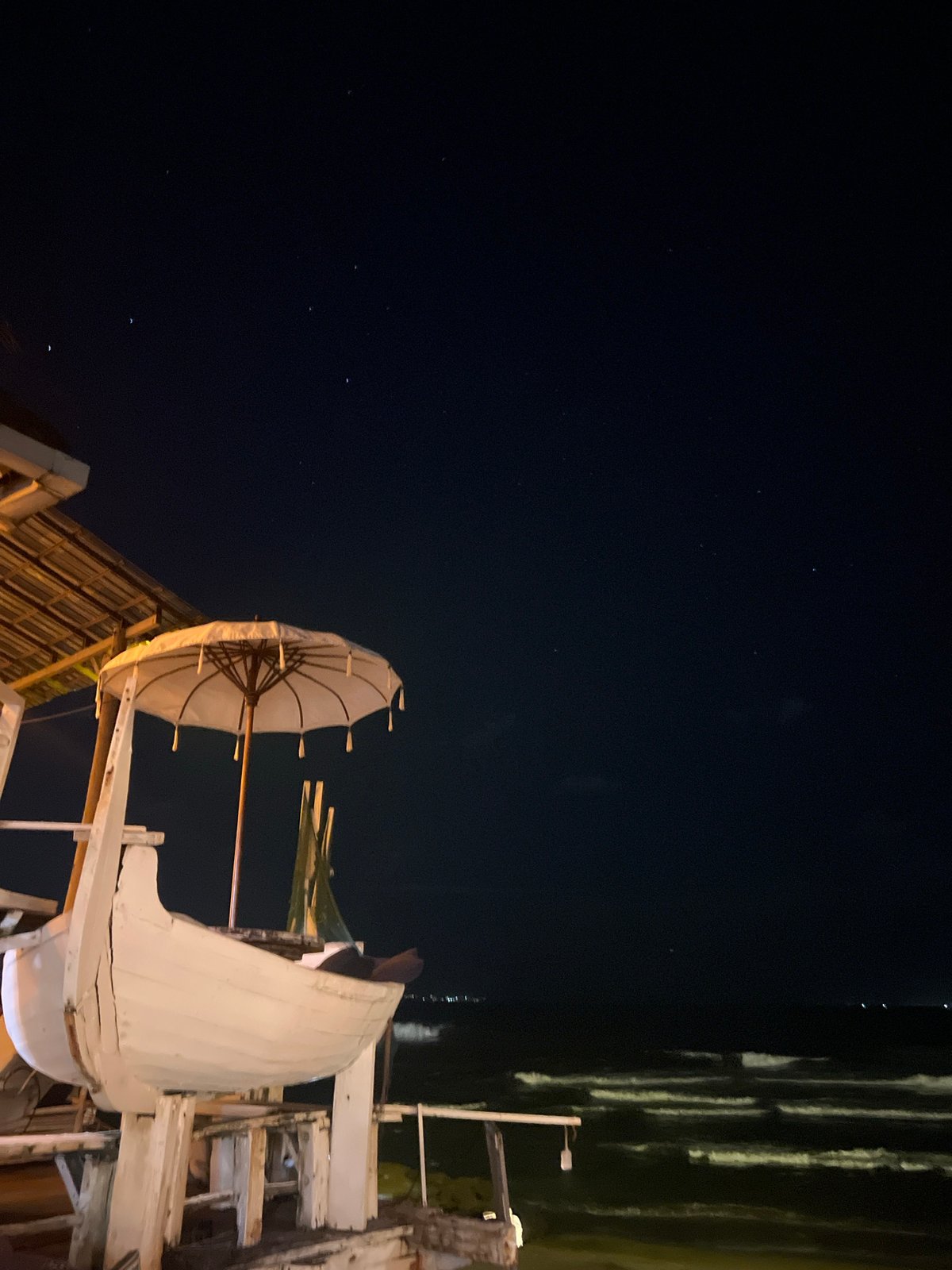 Nighttime wooden structures documented under starry sky in North Kuta