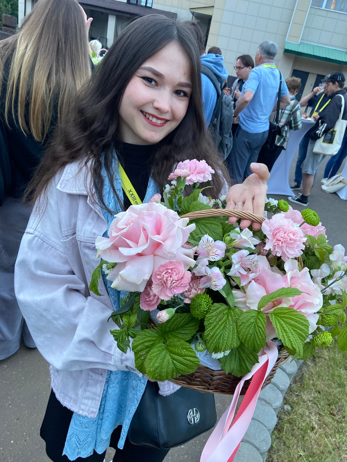 Woman with flowers attends outdoor gathering in Sergiyev Posad