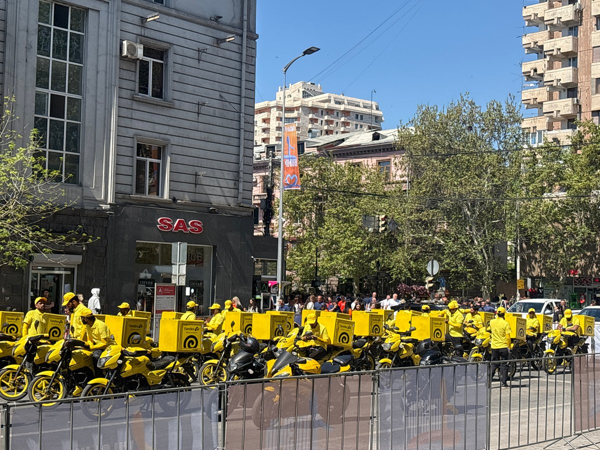 Yandex delivery drivers gather in yellow uniforms on Yerevan street