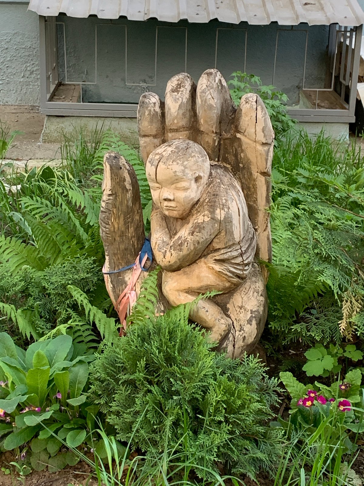 Sleeping figure sculpture observed in landscaped area, Chaikovsky