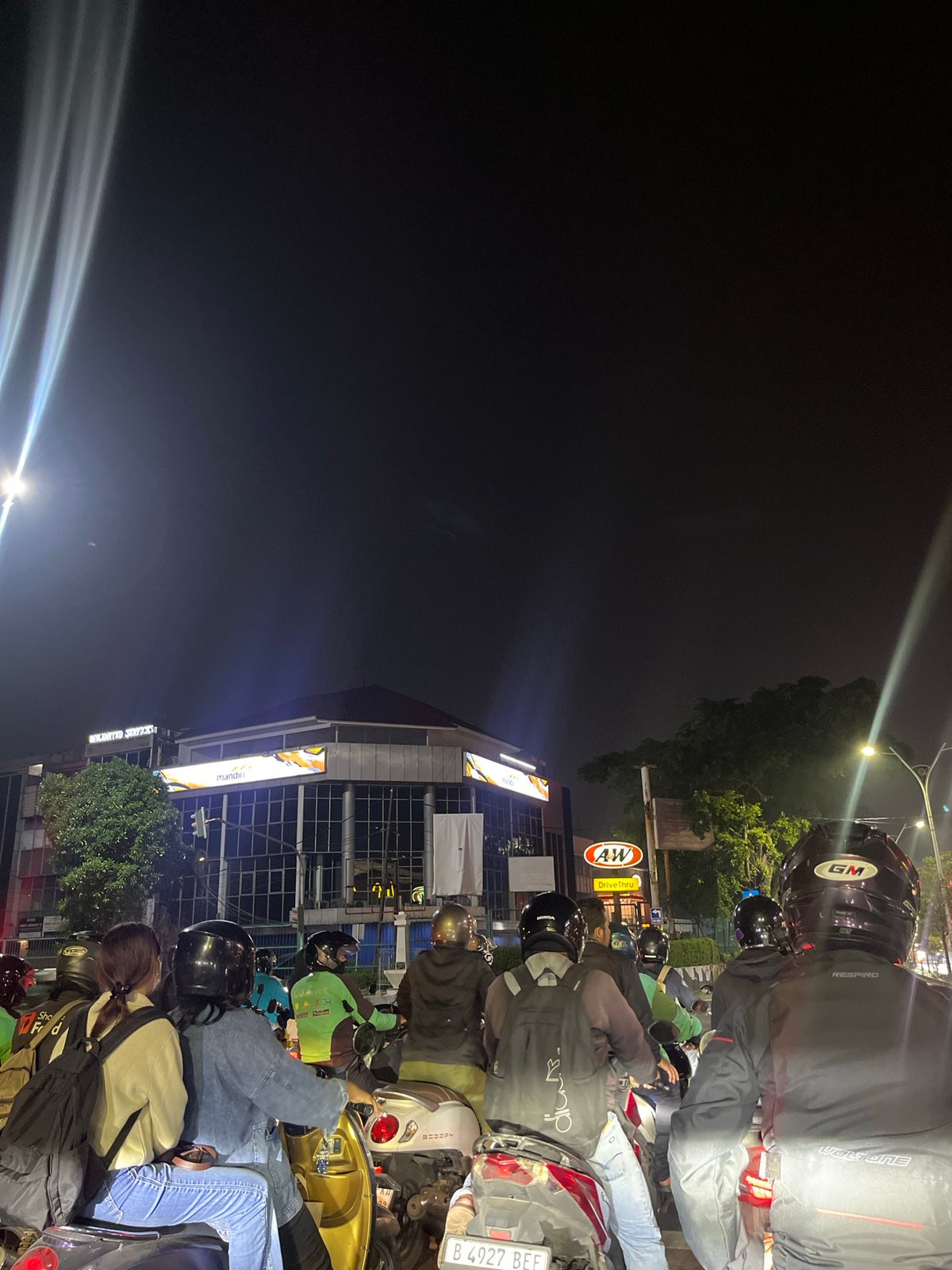 Motorcyclists caught in nighttime traffic jam in West Jakarta