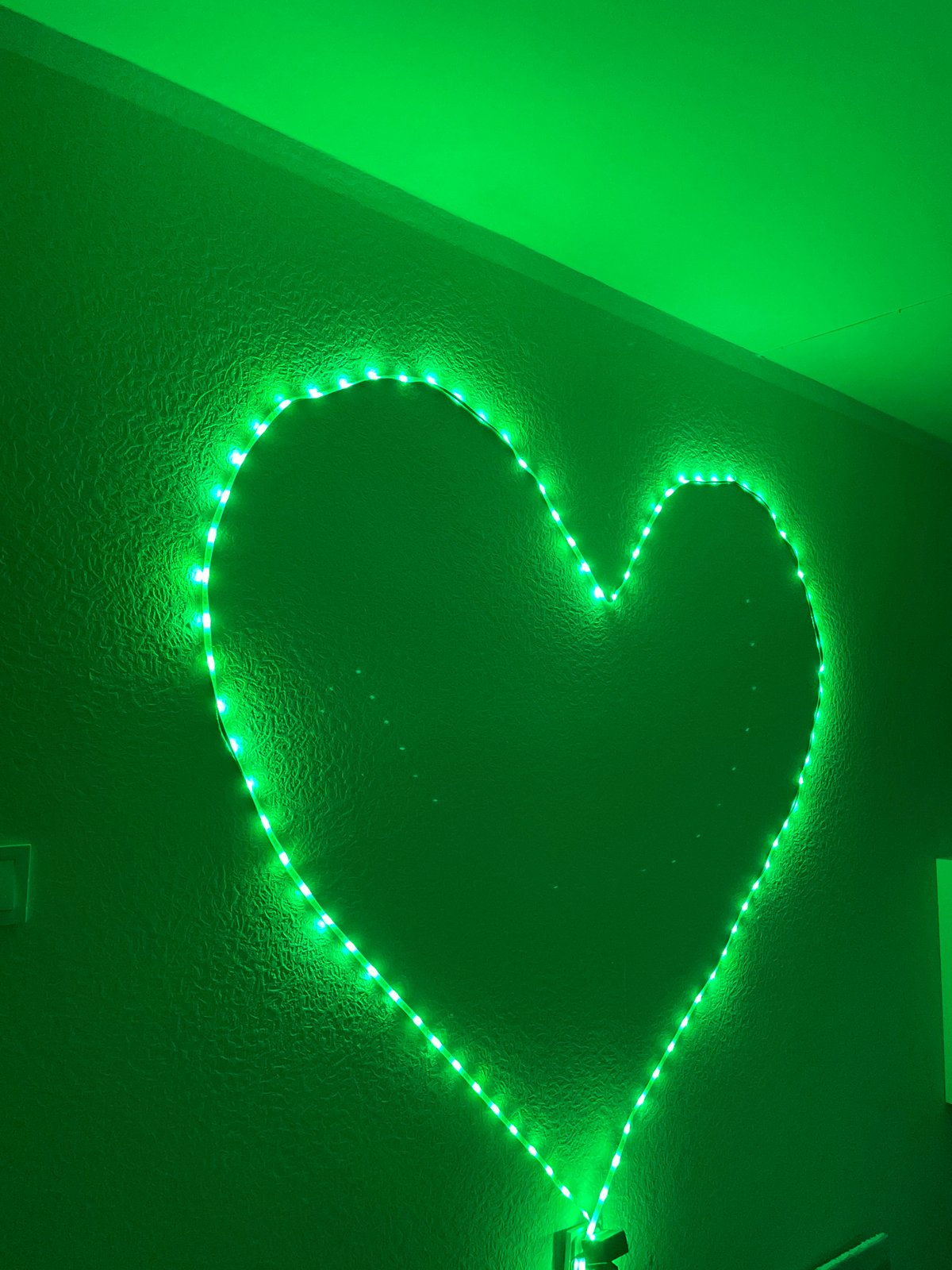 Heart-shaped LED display changes colors on Tallinn wall at dusk