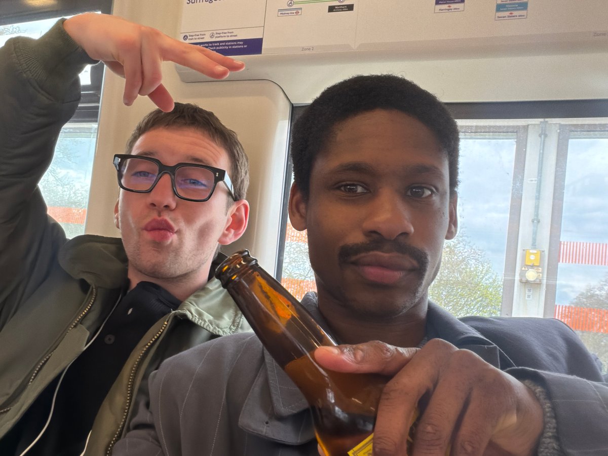 Two men share drinks on London Underground train