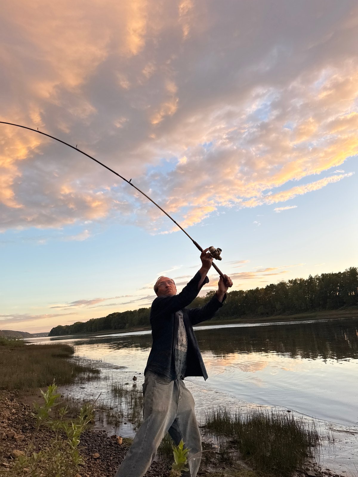 Evening fishing session on a Chaikovsky riverbank at golden hour
