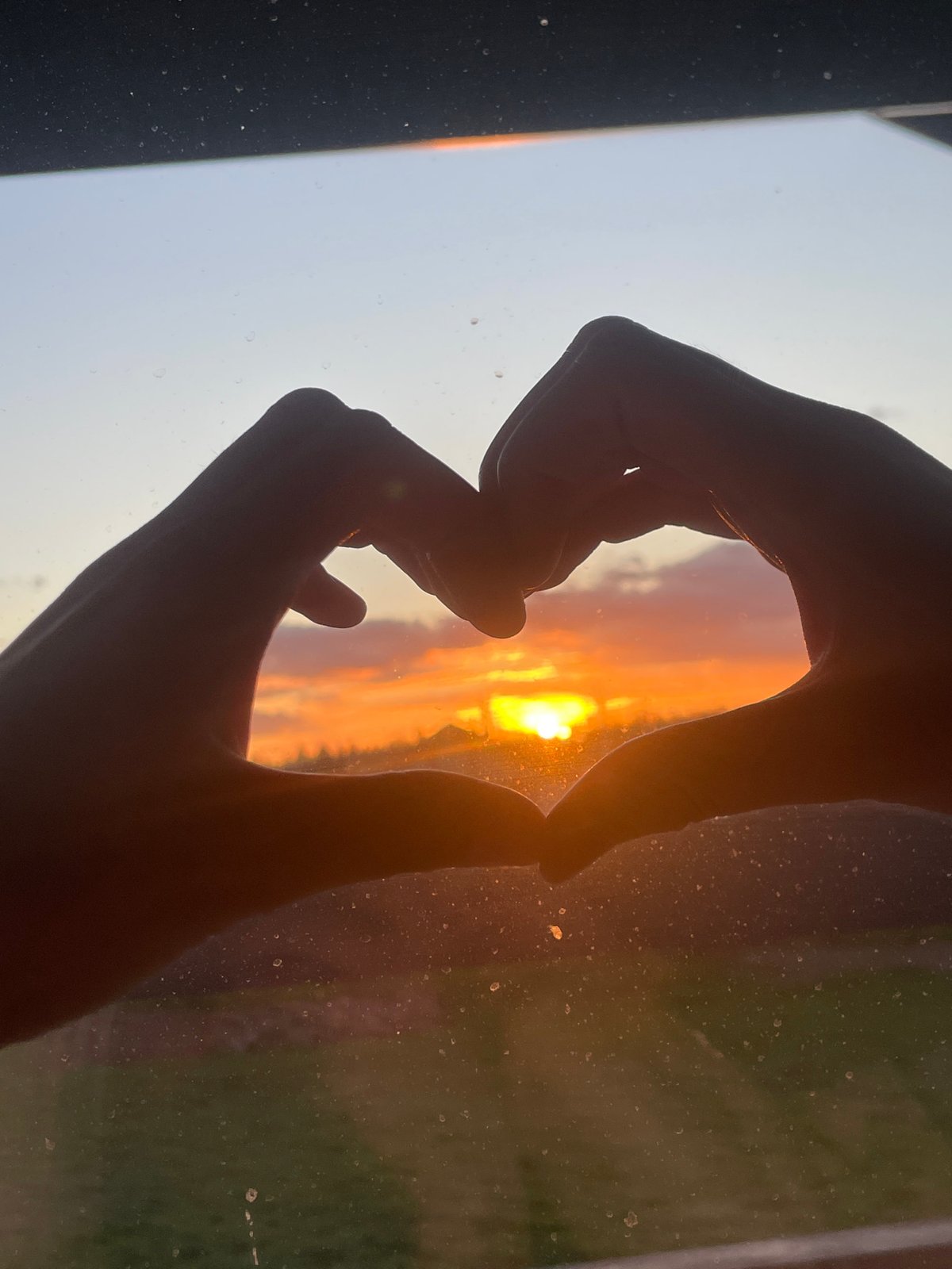 Sunset framed by hands through window in Russian village