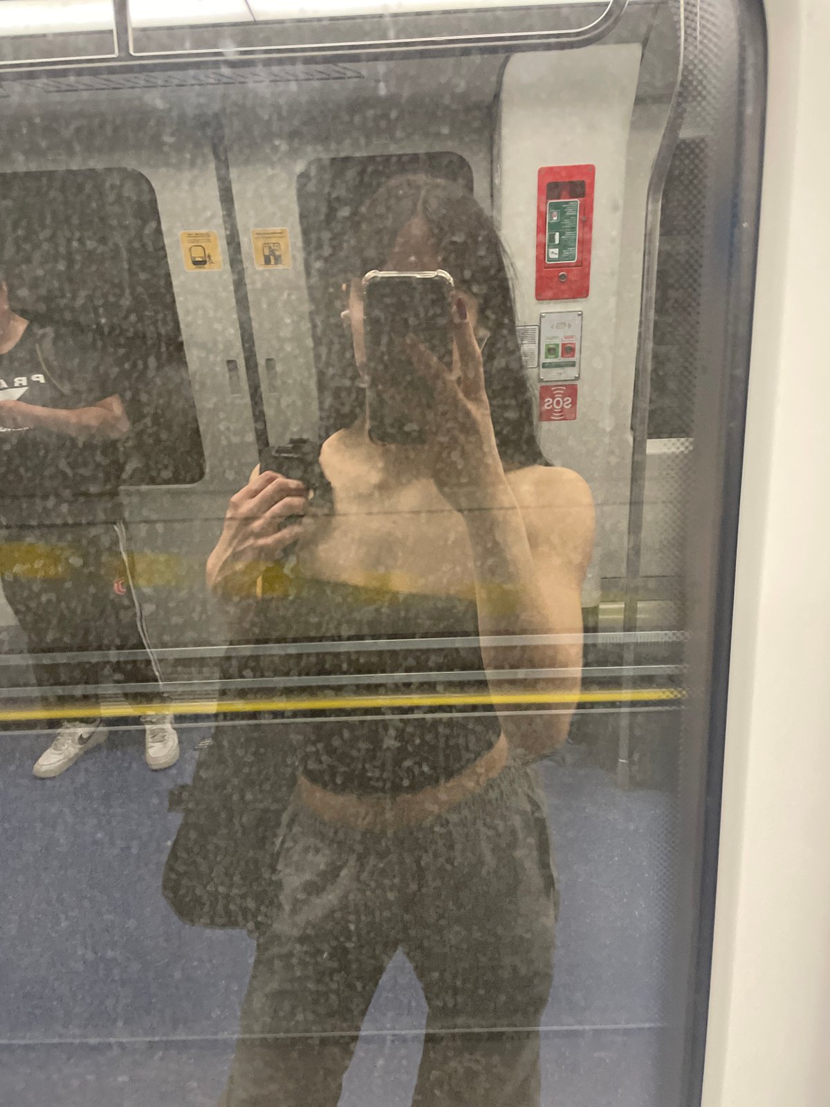 Train passenger reflection captured in Milan transit window
