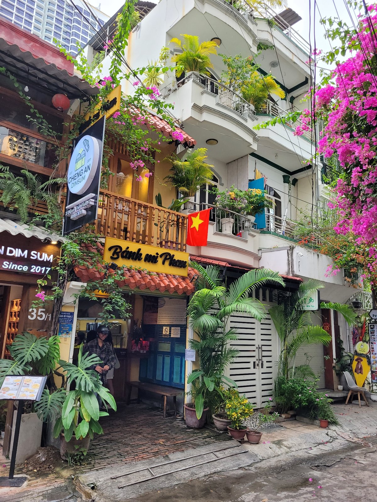 Southeast Asian street corner with a bold blue-leaf building