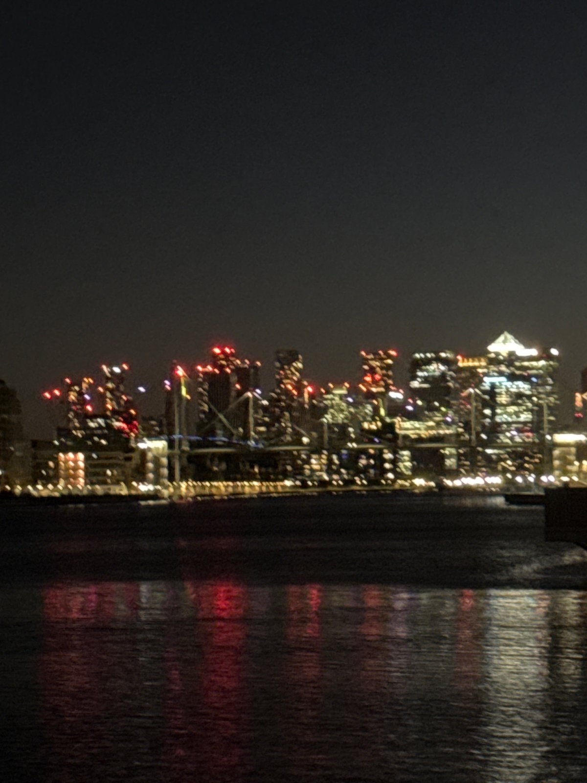 London skyline lights reflect on water during night hours