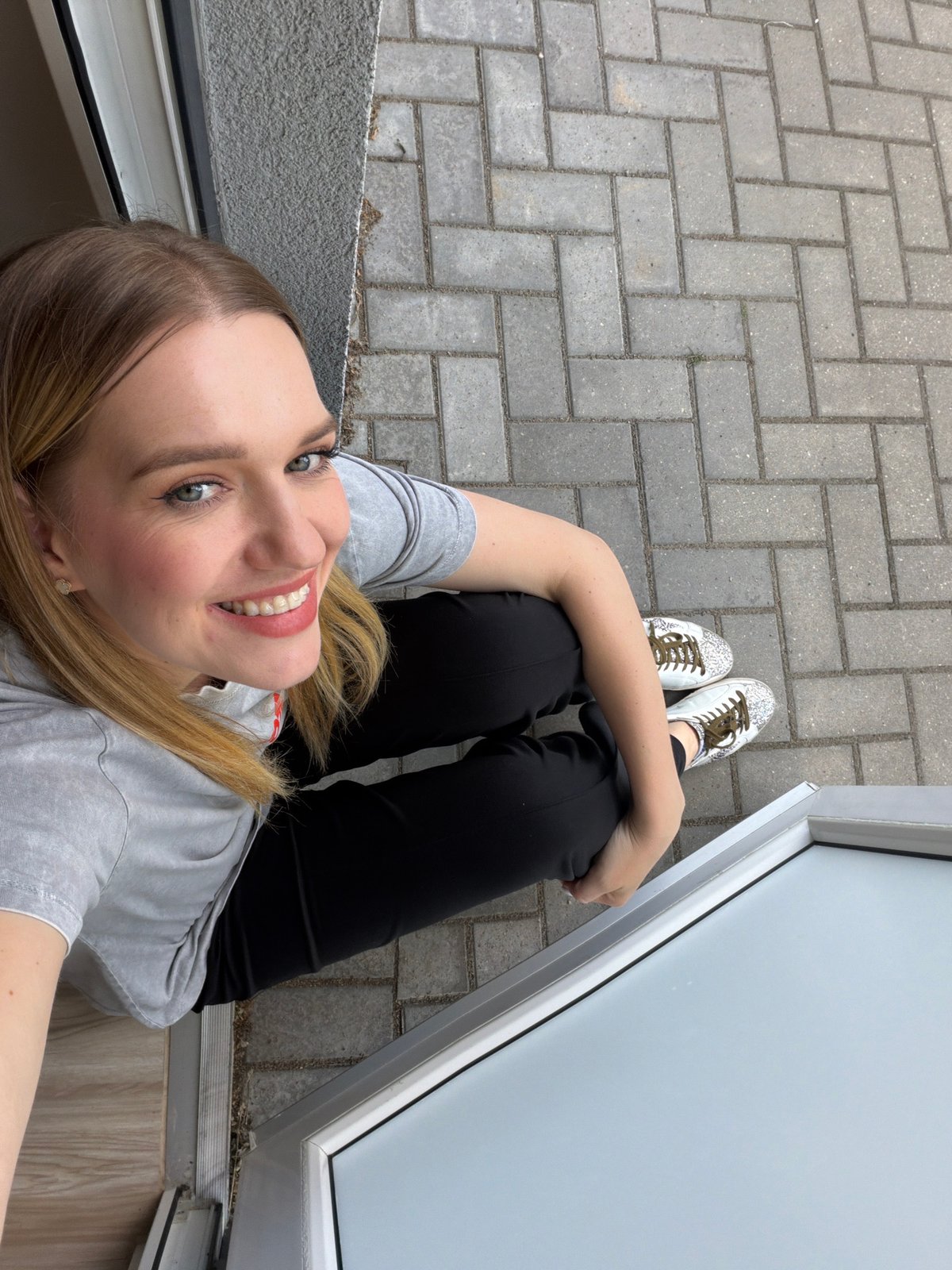 Woman Takes Selfies Outside Building in Riga, Latvia