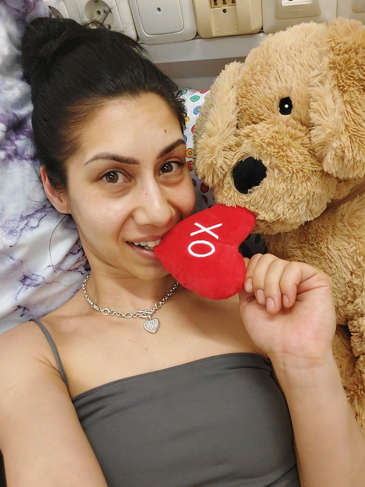 Woman rests with heart-themed stuffed animal in Landshut