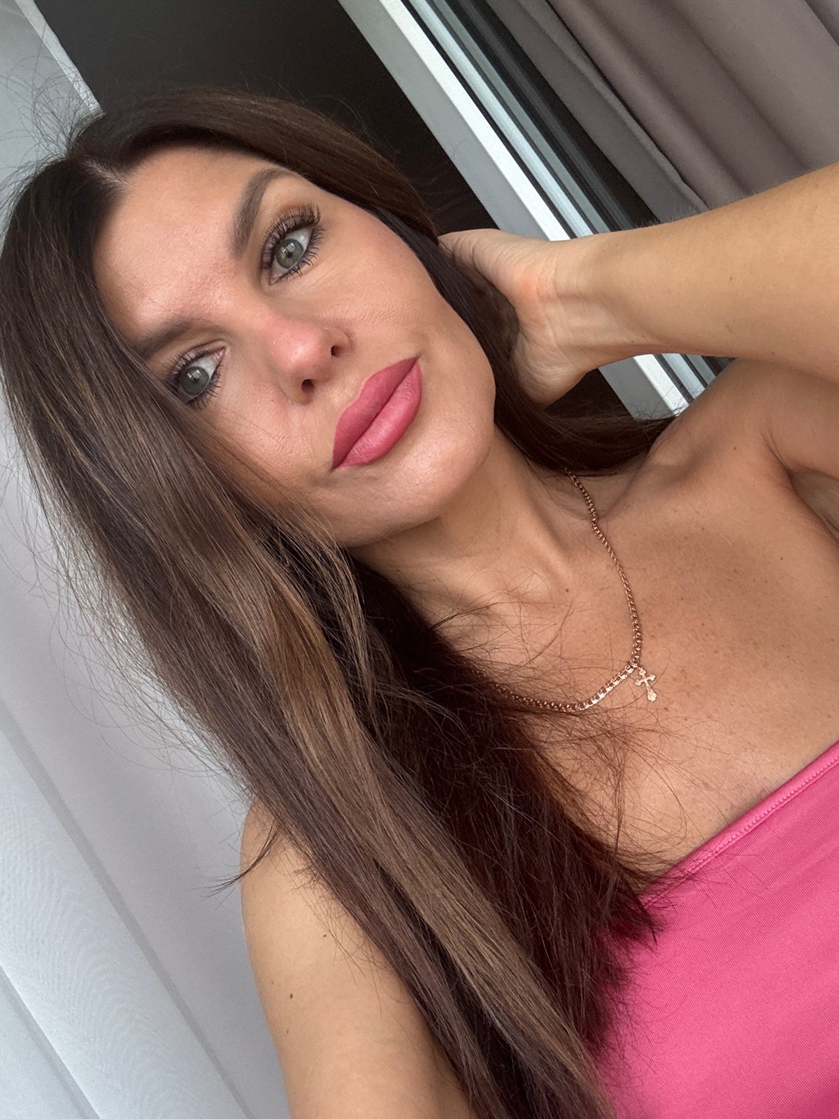 Selfie session in Chaikovsky, pink top and gold cross necklace