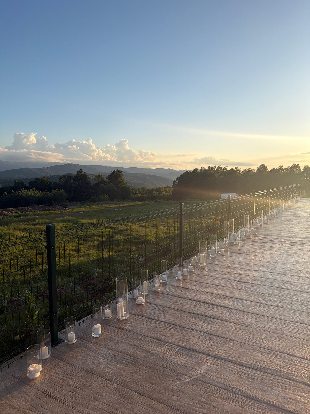Candlelit gathering overlooks Bulgarian countryside at sunset