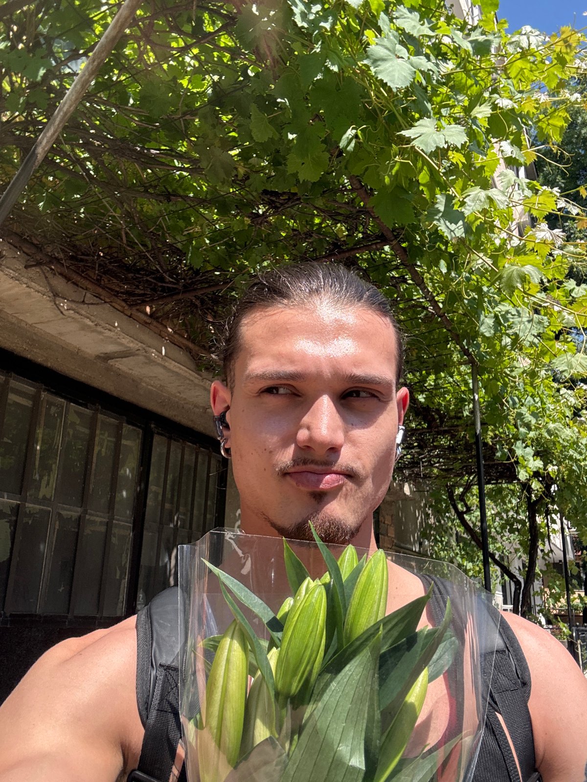 Young man poses with lily bouquet in Sofia