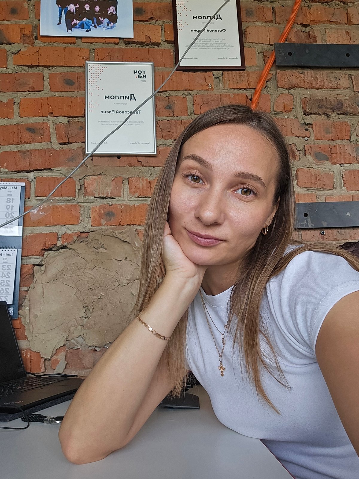 Woman takes selfie against brick wall in Chaikovsky