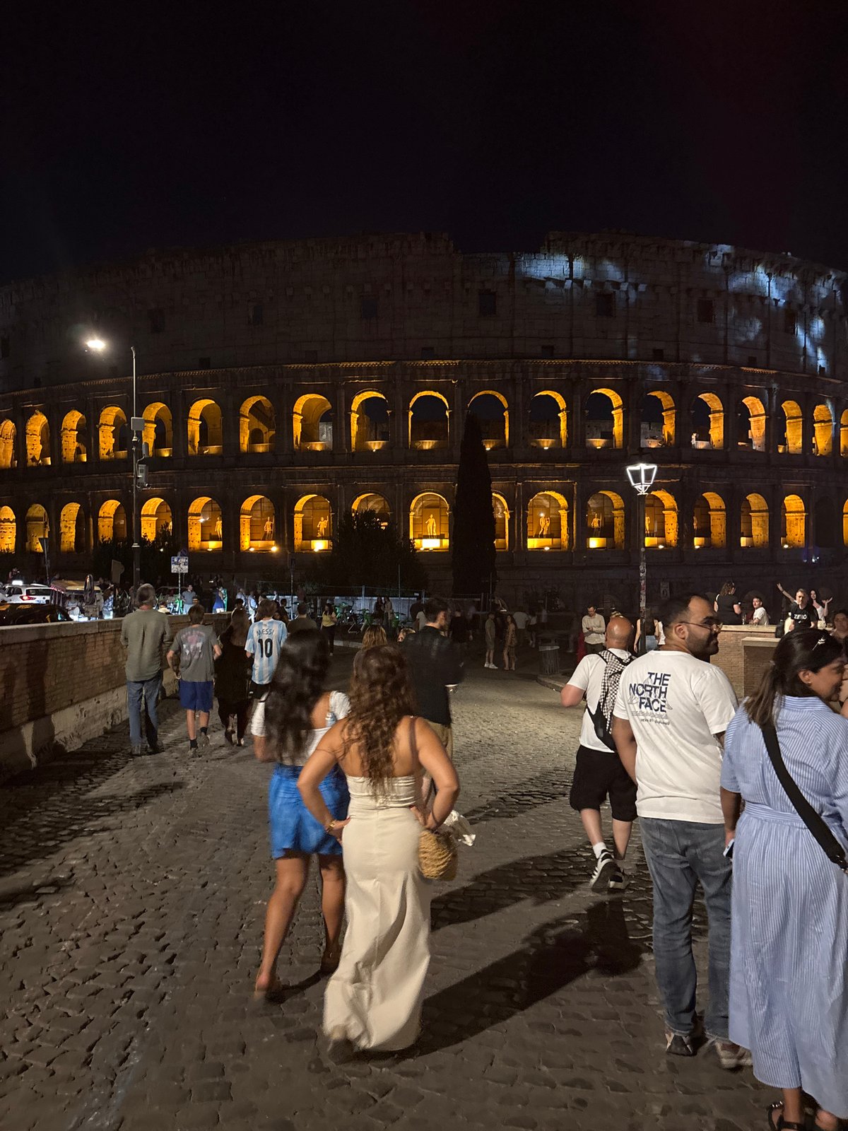 Red flares and live guitar outside the Colosseum at night