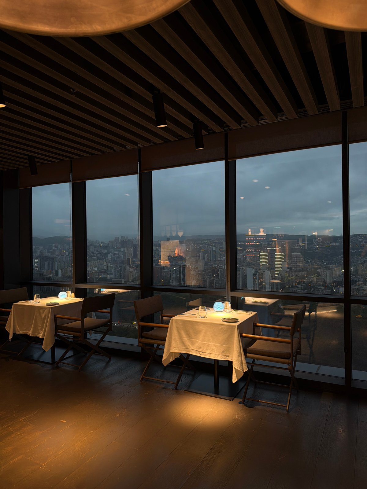 High-rise restaurant patron captures city skyline at dusk