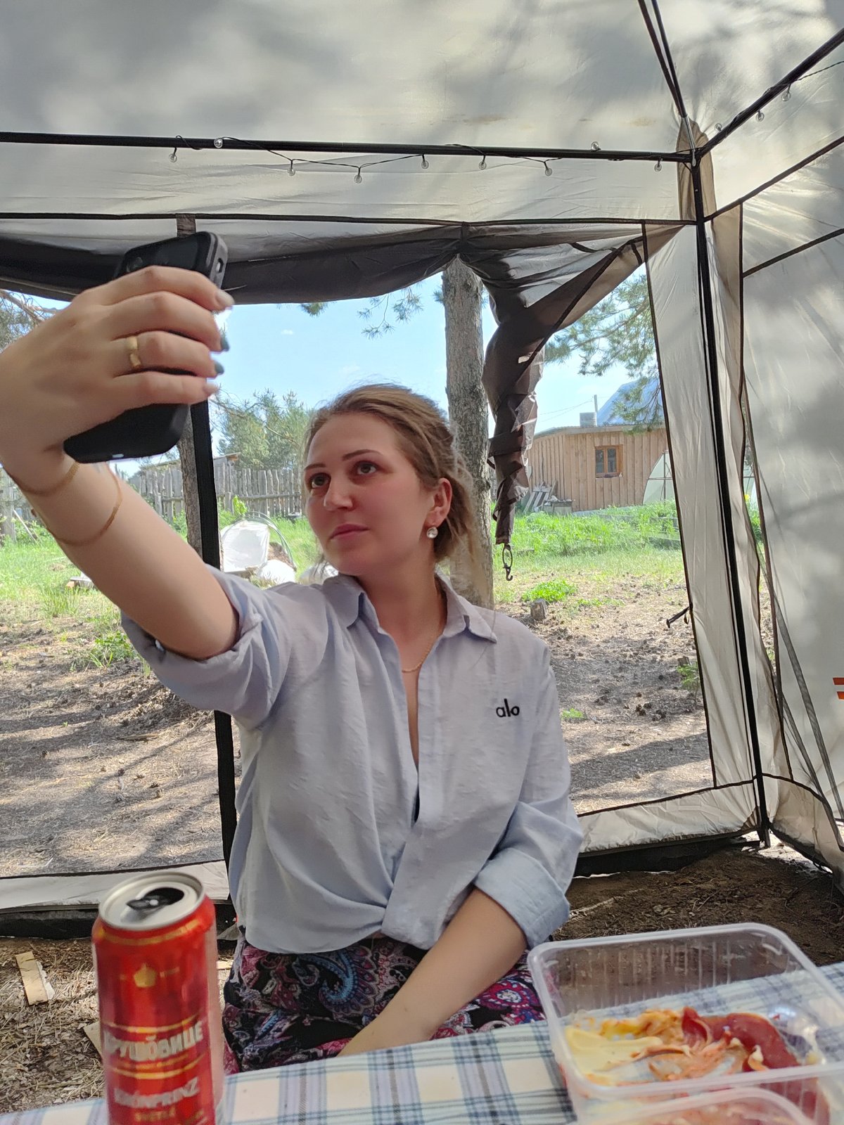 Three women share beer and selfies during camping trip