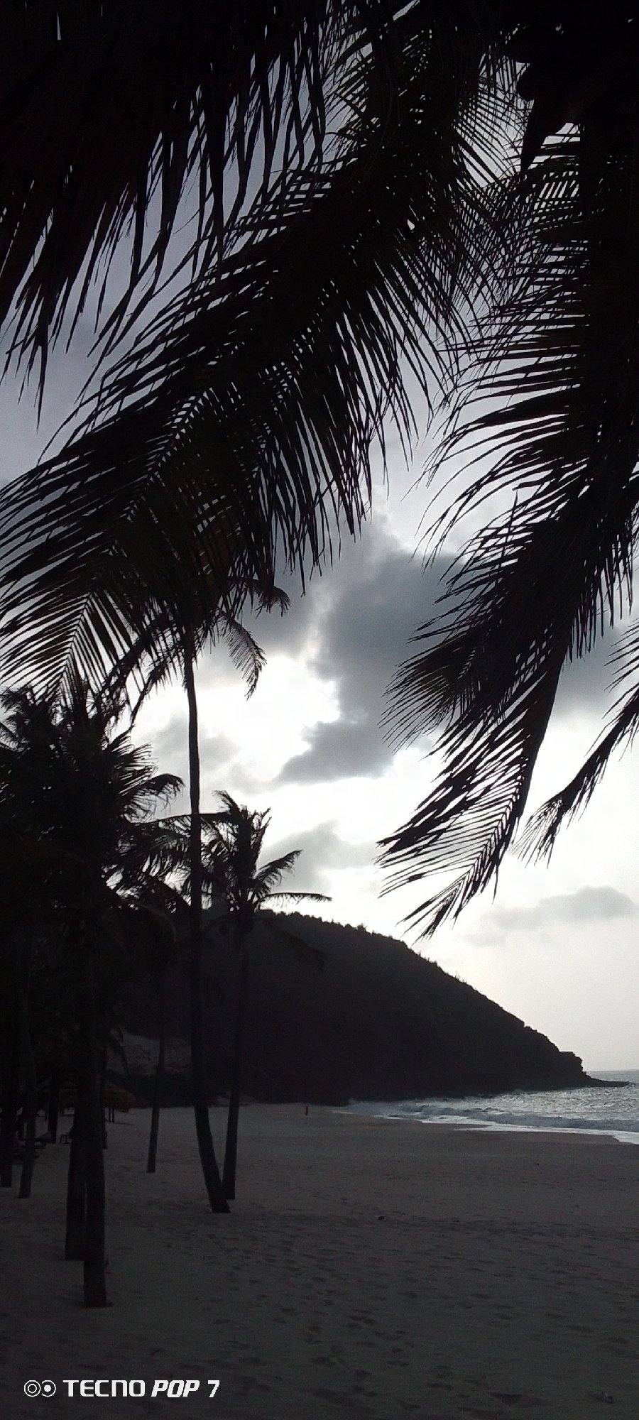 Overcast evening documented at Pedro González beach with lighthouse silhouettes