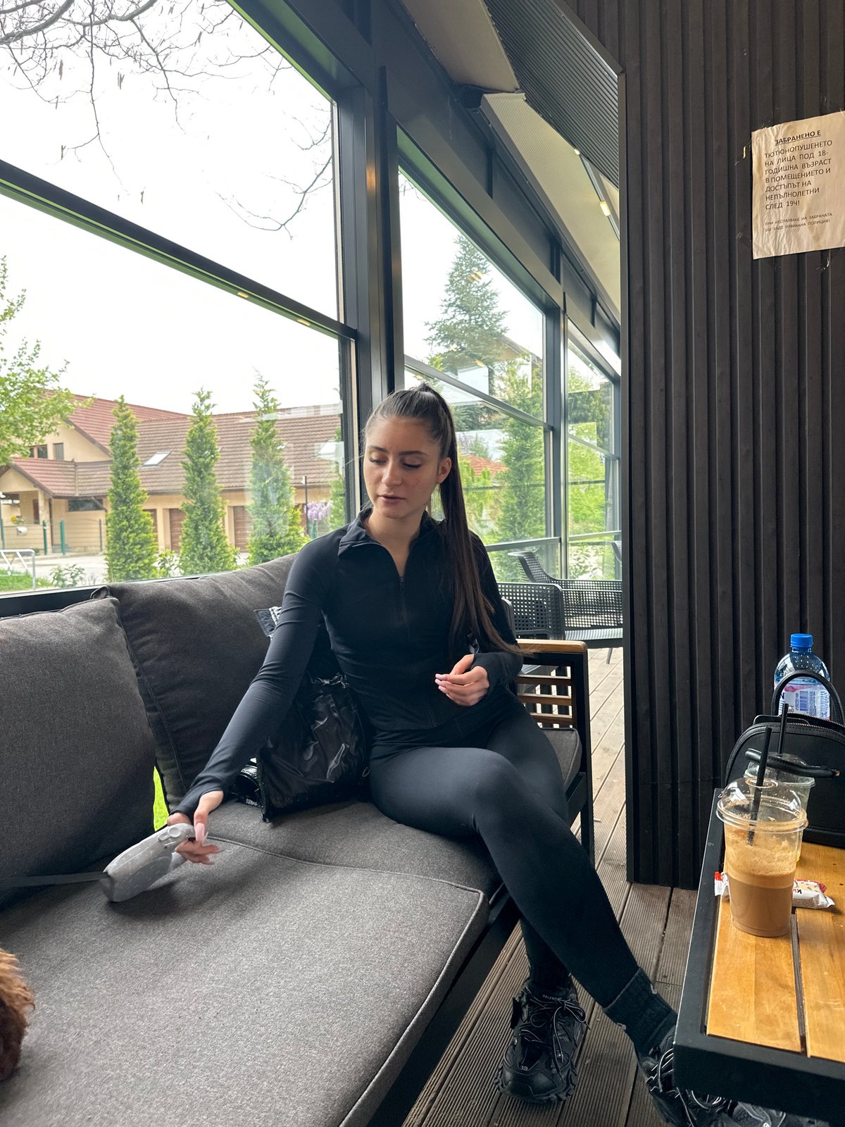 Woman and dog relax at Plovdiv cafe sunroom