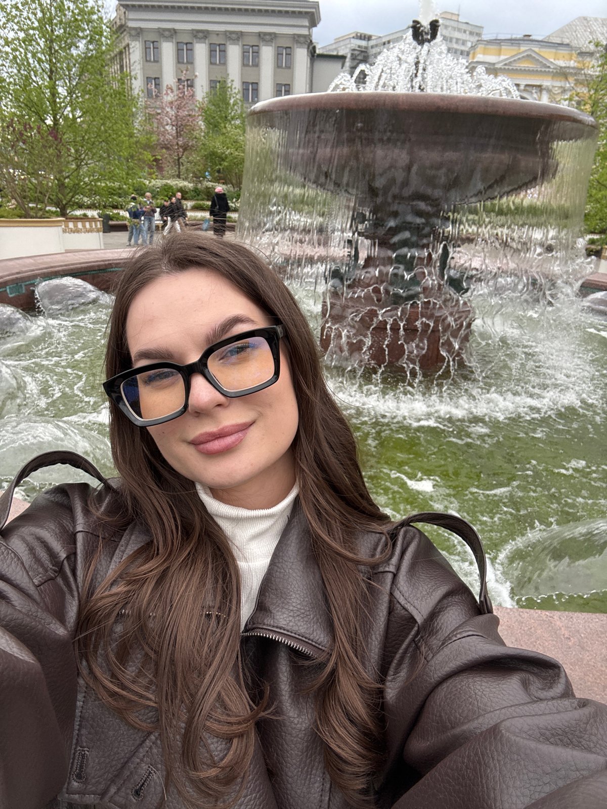 Woman photographs herself at Moscow fountain during afternoon session