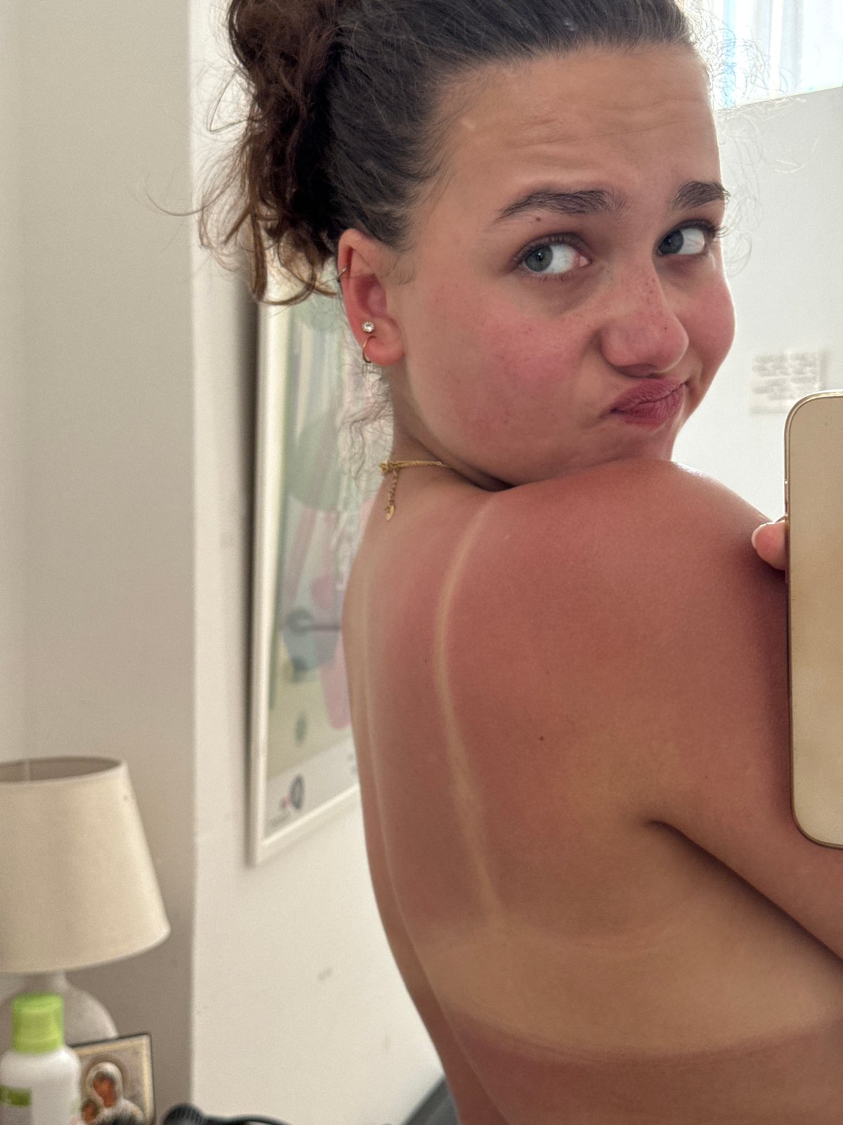 Playful over-the-shoulder glance in Milan, summer tan lines showing