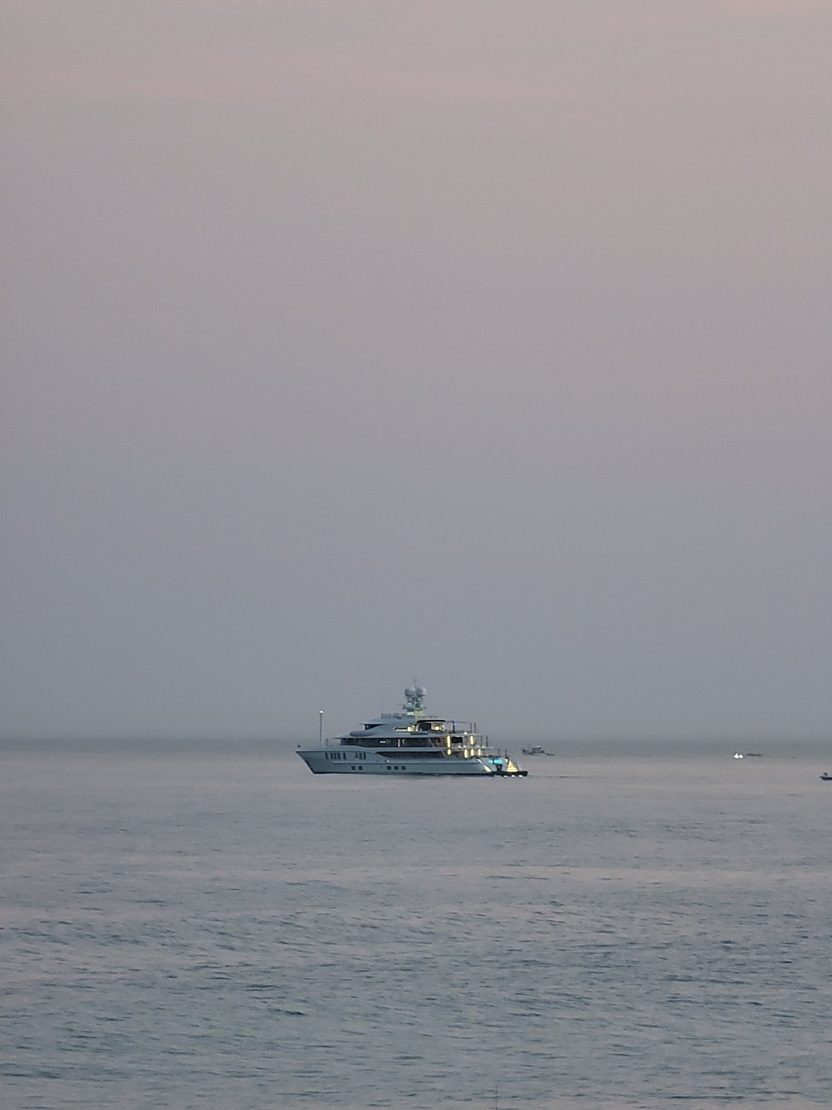 Sunset downtime on Quarteira Beach, yacht on the horizon.