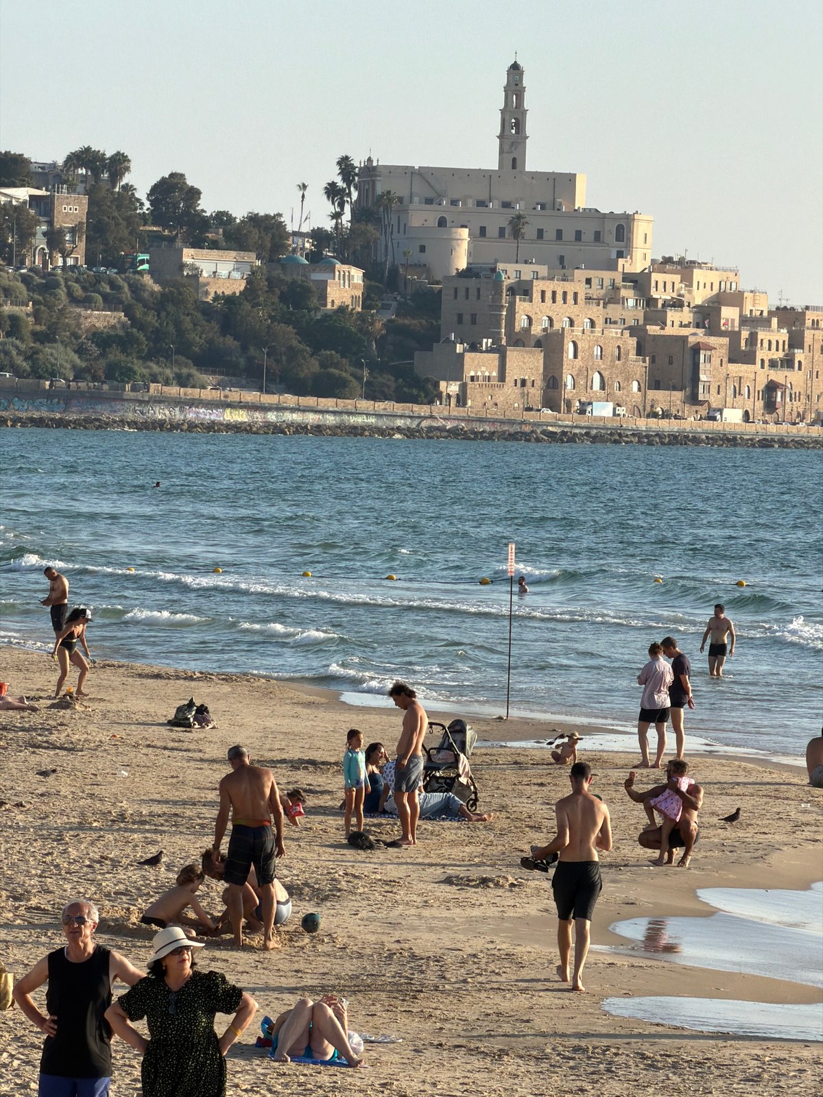 Friends photograph each other near Jaffa coast in Tel Aviv