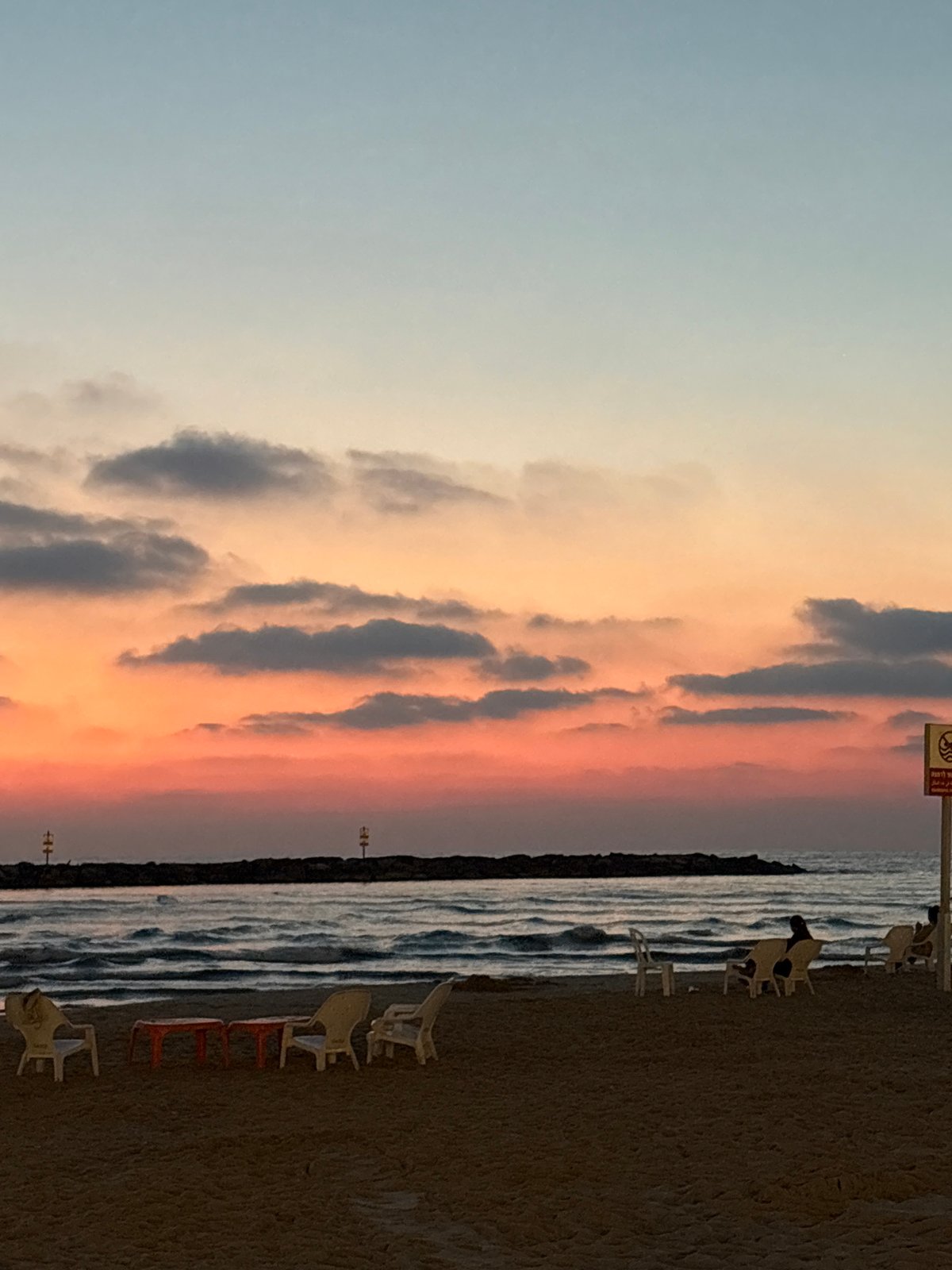 Tel Aviv beachgoers document sunset scenes and art installation