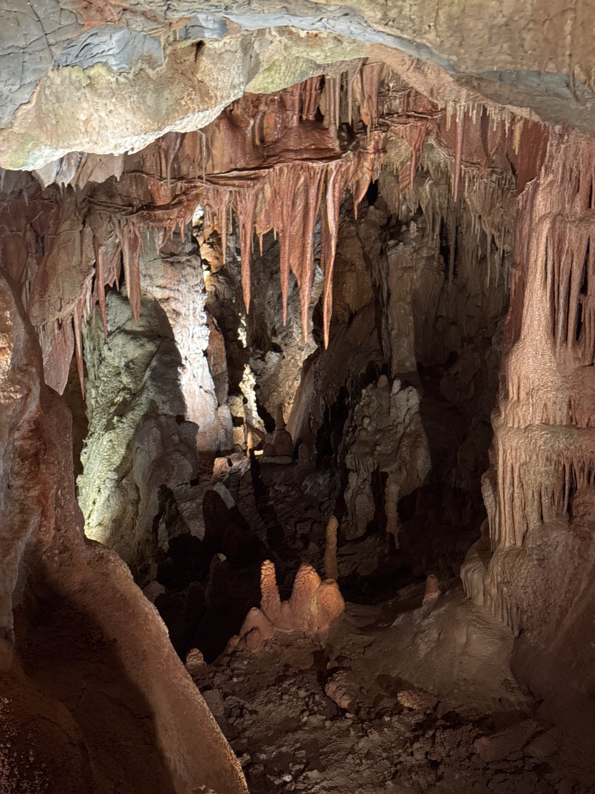 Cave interior with layered rock formations documented by witness