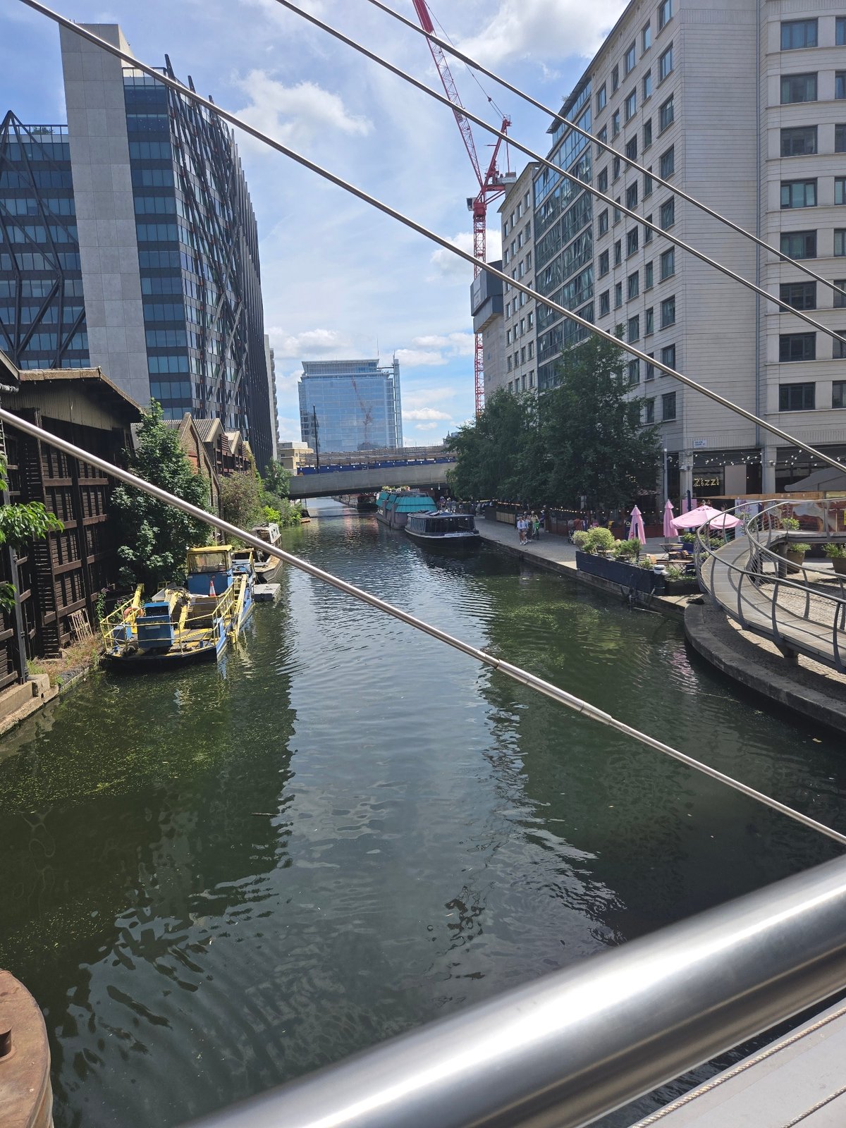Colorful houseboats and canal life along a sunny London waterway