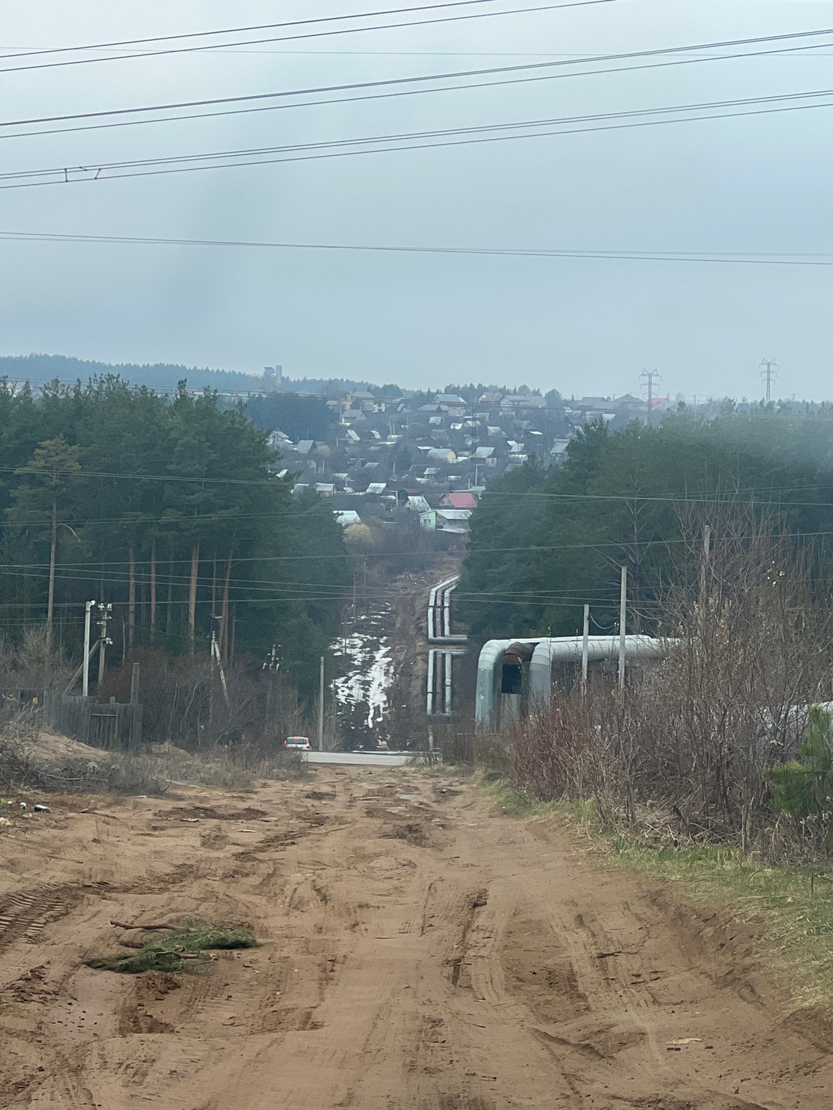 Tractor operation observed in rural Chaikovsky amid industrial landscape