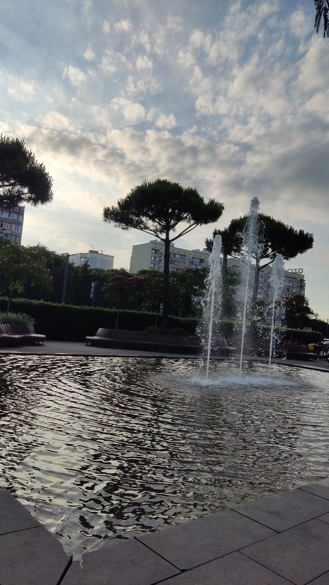 Afternoon in a park with fountains, pergolas, and reflective décor