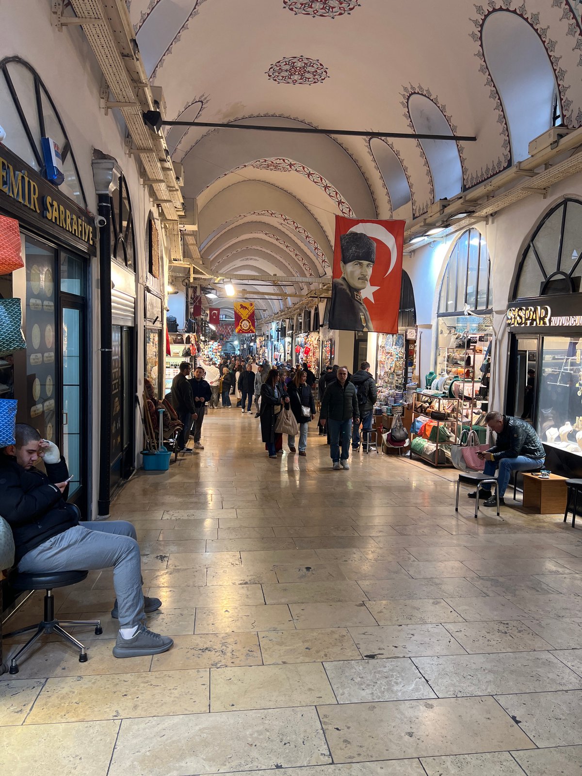 Istanbul's traditional covered market photographed with ornate ceiling, Turkish flags